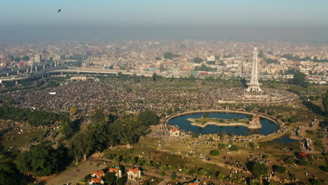 Thousands-Of-People-Gather-At-Greater-Iqbal-Park-With-Minar-e-Pakistan-Monument-In-Lahore,-Punjab,-Pakistan