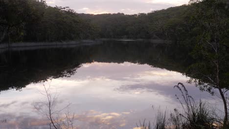 Reflection-Of-Trees-And-Cloudy-Sky-In-The-Calm-Waters-Of-The-Lake-In-Naree-Budjong-Djara-National-Park,-North-Stradbroke-Island,-Queensland,-Australia---wide-shot