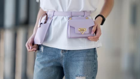 close-up-of-a-waist-length-purple-micromusk-on-a-girl-in-jeans-and-a-white-blouse