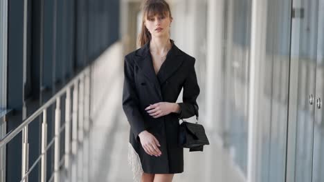 Close-up-portrait-of-a-stylish-black-dress-on-a-skinny-girl-with-a-handbag-in-his-hands