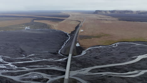 Dramatic-Aerial-View-Mulakvisl-Glacial-River-Bridge-Horizon-Reveal