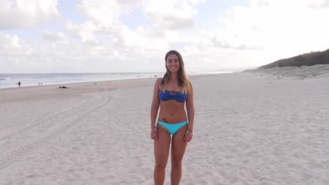 Smiling-Girl-In-Blue-Swimsuit-Stand-At-Beach---Main-Beach-At-Point-Lookout,-North-Stradbroke-Island,-QLD,-Australia