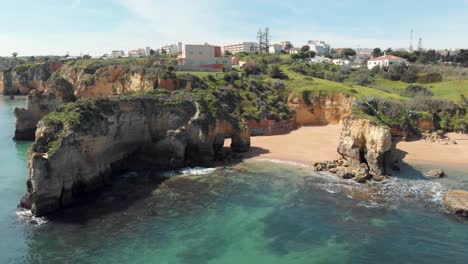 Little-Estudante-Beach-surrounded-by-rock-formations-near-Lagos,-Algarve,-Portugal---Aerial-Panoramic-Tracking-shot