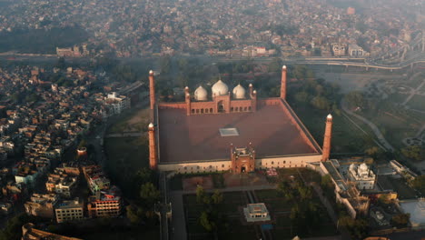 Patrimonio-Mundial-De-La-Unesco---Mezquita-Badshahi-Con-Fondo-De-Vista-De-La-Ciudad-Durante-El-Amanecer-En-Lahore,-Provincia-De-Punjab-En-Pakistán