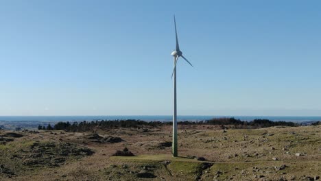 Wind-Turbine,-Alternative-Energy-Power,-Drone-Aerial-View-of-Spinning-Blades-and-Sea-Skyline