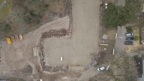 Top-down-aerial-of-construction-workers-walking-on-starting-construction-foundation