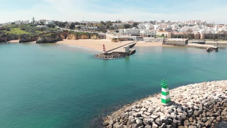 Cais-da-Solaria-and-small-Fort-of-Ponta-da-Bandeira-with-Lagos-cityscape-in-background,-Algarve,-Portugal