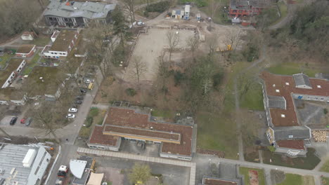 Aerial-of-construction-foundation-surrounded-by-old-buildings