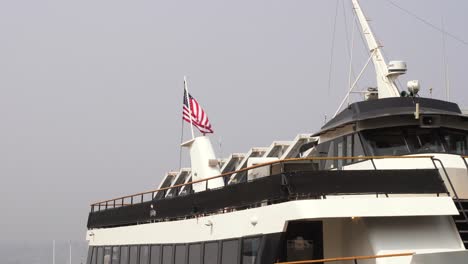 American-flag-on-top-of-a-ship-waving-through-the-coastal-breeze-of-the-Pacific-Ocean-in-San-Diego,-California