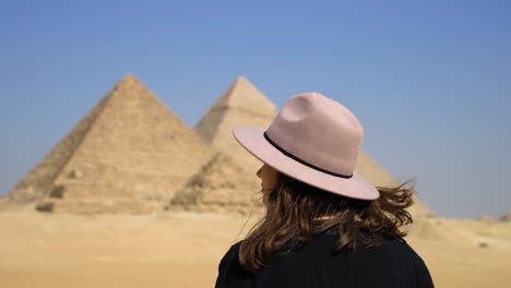 Female-Tourist-With-Purple-Hat-Looking-At-The-Great-Pyramid-Of-Giza-In-Cairo,-Egypt-At-Sunny-Day