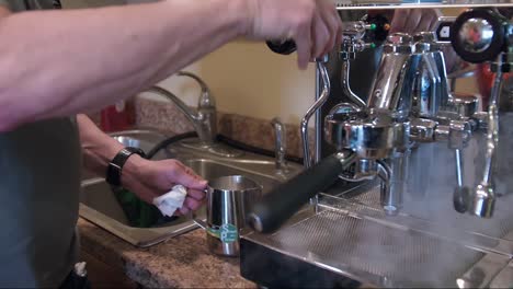 Barista-steaming-milk-in-machine-to-make-coffee,-cappuccino,-latte,-close-up