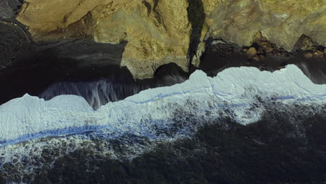 Foamy-Waves-Breaks-Through-Coastal-Mountains-At-Black-Sand-Beach-Of-Reynisfjara-In-Southern-Iceland