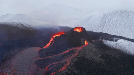 Aerial-view-around-volcano-lava-fountains,-in-middle-of-snowy-nature---orbit,-drone-shot