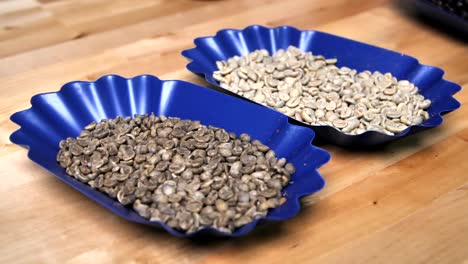 Fresh-green-coffee-beans-in-two-blue-bowls,-slow-motion-circle-shot