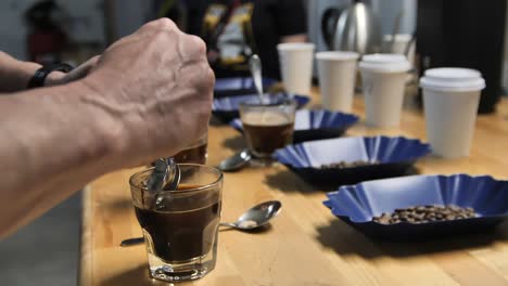 A-Master-Taster-using-coffee-cupping-to-test-quality,-slow-motion-close-up