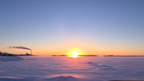 Majestätischer-Orangefarbener-Sonnenuntergang-über-Verschneitem-Winterflachland-In-Finnland