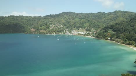 A-coastal-fishing-village-with-boats-anchored-at-sea-and-mountains-in-the-background-at-Charlotteville,-Tobago