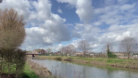 4K-time-lapse-of-the-river-tone-in-Taunton-Somerset-England,-clouds-moving-in-the-blue-sky-over-the-river,-30fps