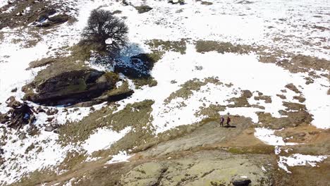 Drone-shot-of-hikers-hiking-on-a-mountain-covered-in-snow