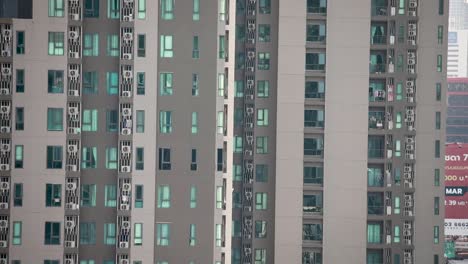 Condominium-Building-panning-upward-in-Bangkok,-Thailand-with-windows-on-the-side-of-the-building