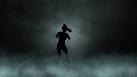 A-modern-youth-dance-performed-by-a-graceful-and-sexy-female-silhouette,-in-the-smoke-against-the-backdrop-of-spotlights
