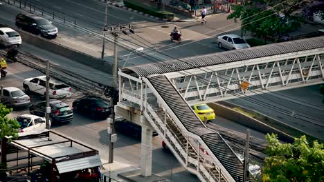 Footbridge-over-road-in-Bangkok,-Thailand-with-busy-traffic