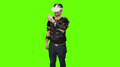 Man-in-white-VR-oculus-vr-virtual-headset-pointing-and-swiping-with-motion-tracker-capture-vest-in-front-of-green-screen-chroma-key-playing-with-mixed-augmented-reality-3d-project-advanced-technology