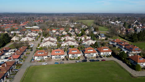 Aerial-of-suburban-neighborhood-at-the-edge-of-green-meadow