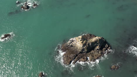 Bird's-Eye-View-Of-Sea-Stack-With-Birds-At-Daytime---aerial,-top-down