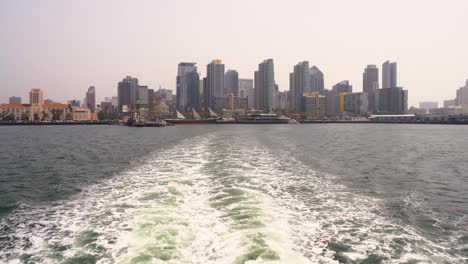 San-Diego,-California-bay-harbor-view-of-the-downtown-city-skyline-filled-with-skyscrapers-and-beautiful-hotels-and-business-buildings-surrounded-by-the-ocean-water,-boats,-ship-docks-and-marinas