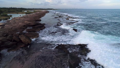 Aerial-view-over-rocks-and-waves-on-the-coast-of-Playa-Los-Cuadritos-beach,-in-San-Cristobal---low,-drone-shot