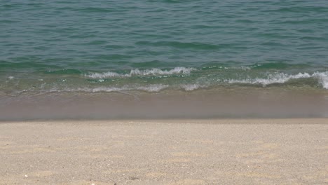 Foamy-Waves-Washing-white-Sandy-Beach-In-Gangneung,-South-Korea---close-up