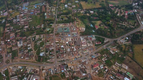 Aerial-view-overlooking-traffic-in-village-in-rural-Kenya---high-angle,-tracking,-drone-shot