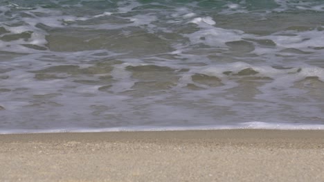 Foamy-Waves-Washing-Sandy-Beach-In-Gangneung,-South-Korea---close-up