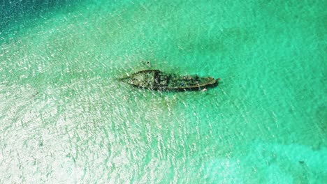 Sunken-shipwreck,-wooden-fisherman's-boat-under-turquoise-clear-water