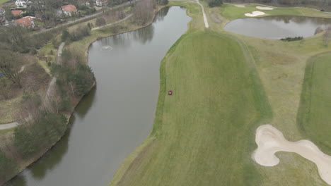 Aerial-of-lawn-mower-mowing-green-on-golf-course