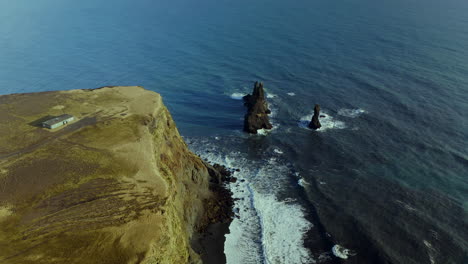 Berühmte-Basaltseestapel-Von-Reynisdrangar-Mit-Plätschernden-Wellen-Auf-Küstenklippen-Am-Reynisfjara-strand-In-Südisland