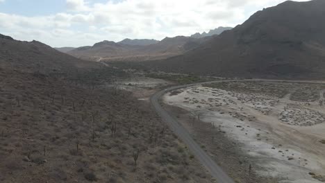 Aerial:-solo-car-driving-on-road-through-remote-Mexican-desert,-La-Paz,-Baja-California-Sur