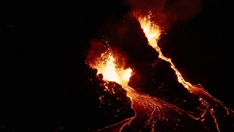Helles-Geschmolzenes-Magma,-Das-Nachts-Aus-Zwei-Öffnungen-In-Der-Erdkruste-Speit