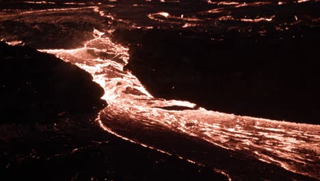 Río-De-Lava-Viscosa-Caliente-Que-Fluye-En-La-Superficie-De-La-Tierra-Por-La-Noche,-Islandia