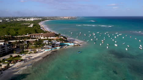 Rotating-drone-shot-of-boats-in-the-ocean-and-coastline-at-Playa-Del-Carmen-Mexico
