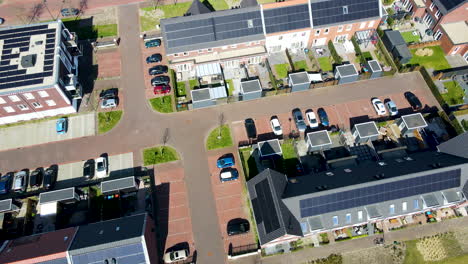 Aerial-of-solar-panels-on-rooftop-of-house,-drone-pulling-back-and-revealing-solar-panel-filled-neighbourhood