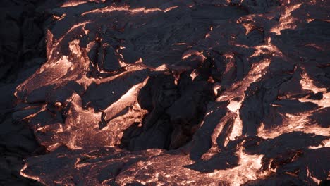 Close-up-of-molten-rock-flows-calmly,-hot-lava-solidifying-slow-at-night
