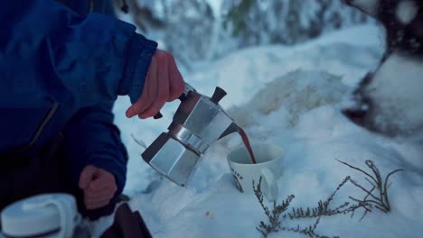 Person-Pouring-Hot-Coffee-Into-Cup-At-Snowy-Season-With-A-Husky-Dog---Outdoor-Leisure---Close-Up-Shot