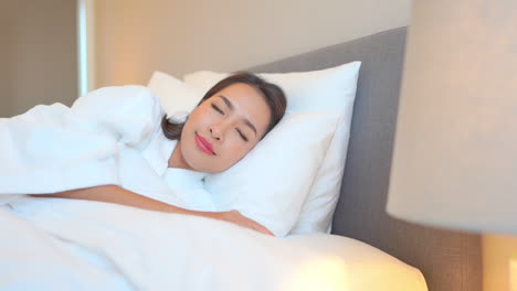 Pan-Close-up-of-a-woman-taking-a-nap-on-a-luxurious-hotel-bed