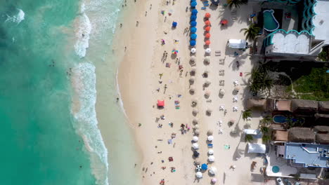 Cinematic-downward-drone-shot-of-people-on-the-beach-in-Playa-Del-Carmen-Mexico