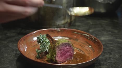 Chef-plating-a-dish-with-Venison-meat-rib-slice