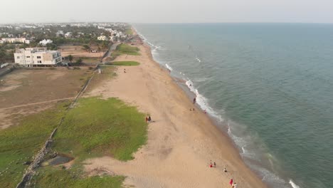 ECR-Chennai-Beach-Full-of-People-Surrounded-By-Trees,-Construction,-and-Buildings-Top-View-During-Sunset