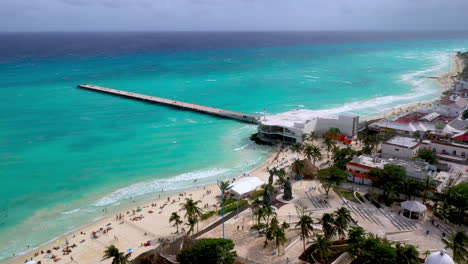 Revealing-drone-shot-of-pier-and-the-resort-coastline-of-Playa-Del-Carmen-Mexico