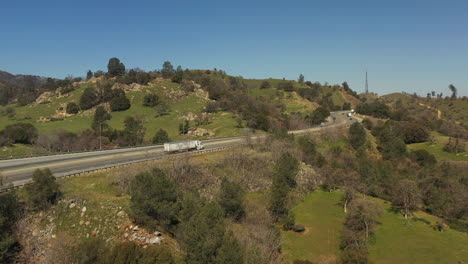 Spring-showers-bring-green-grass-to-the-Tehachapi-foothills---highway-traffic-aerial-view